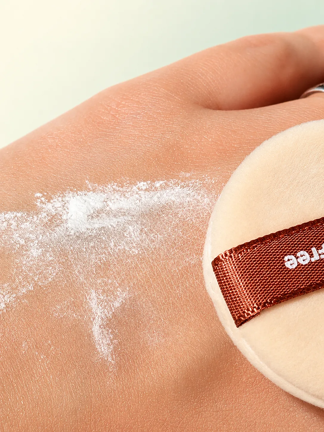 The mineral powder swept onto the back of a hand next to the puff